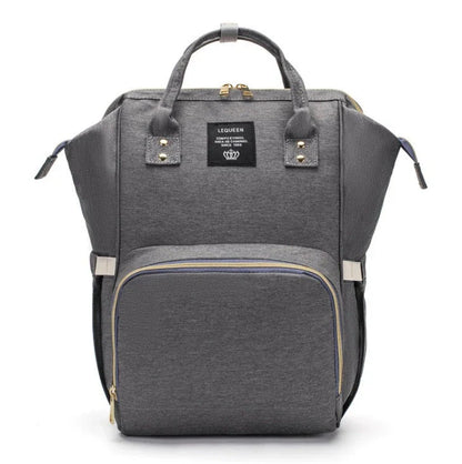 Stylish maternity diaper bag in various colors, featuring a paper bag design, separate bottle compartment, and discreet breastfeeding button.