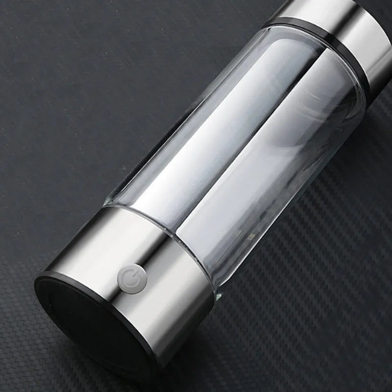 Portable hydrogen water bottle with glass chamber and stainless steel components showing electrolysis bubbles