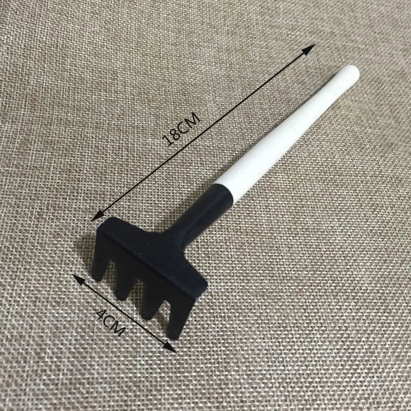 Succulent gardening tool set showing mini shovel, watering can, tweezers, and rake on a table.
