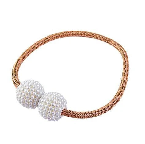 Magnetic curtain tiebacks with white pearl beads and fabric loops holding gathered curtain