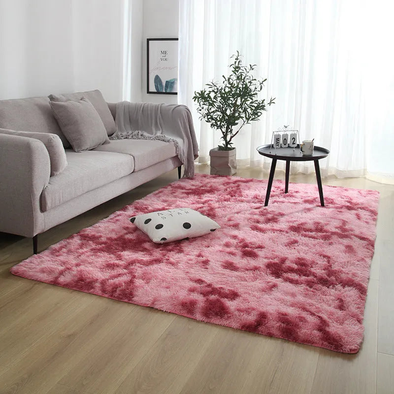 Soft fluffy plain rectangle carpet with anti-slip dots on backing, shown in a light grey colour on a wooden floor.