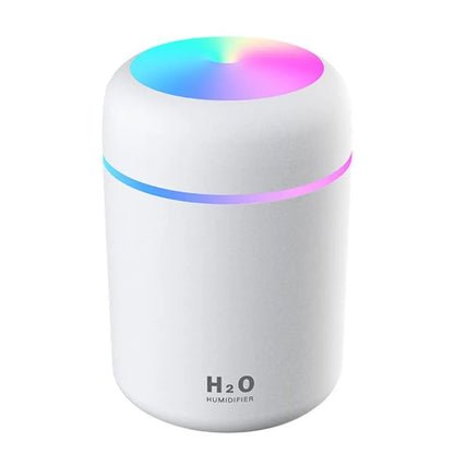 Pink USB desktop humidifier with LED lights and water tank on wooden desk