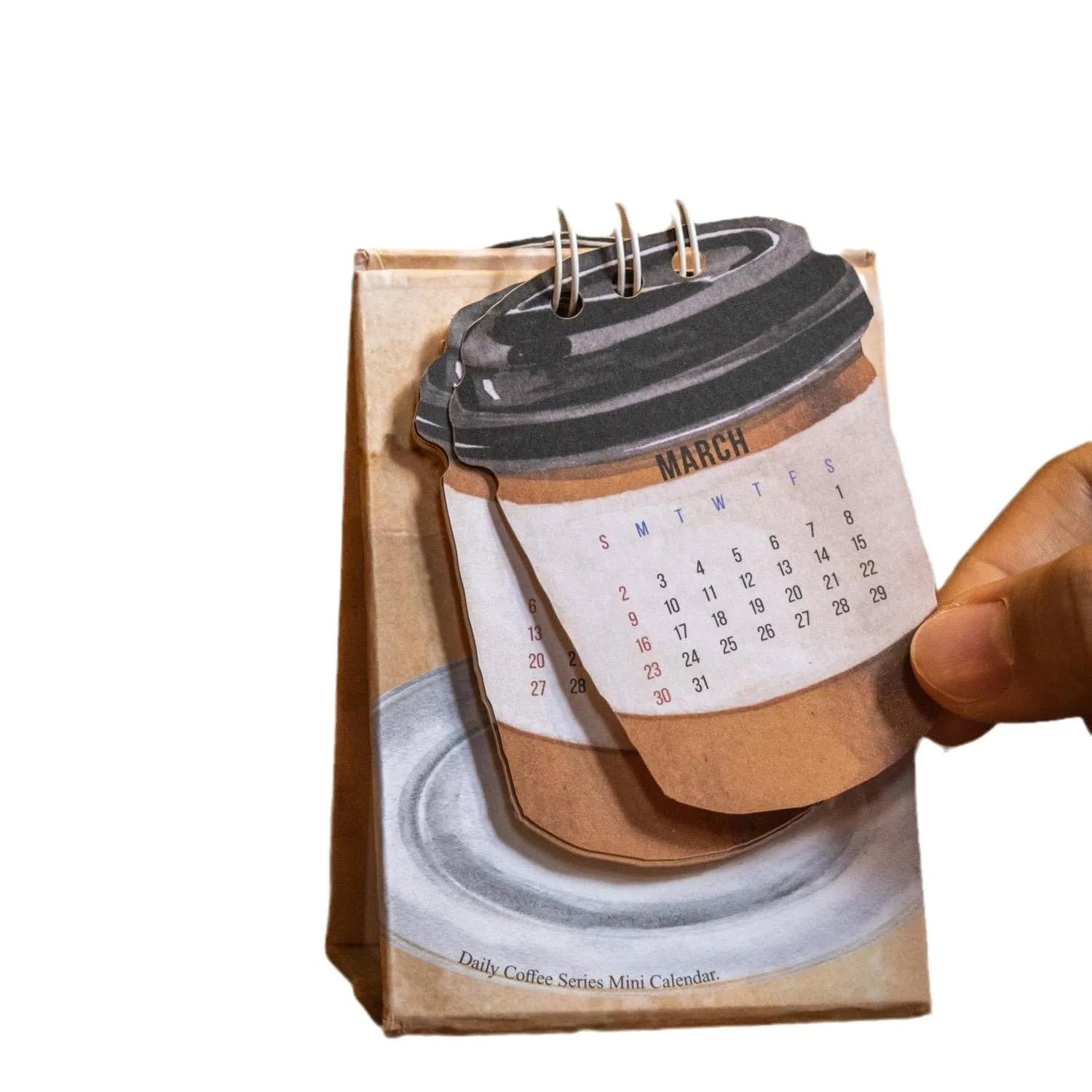 Set of four different themed 2025 mini paper desk calendars on a desk.