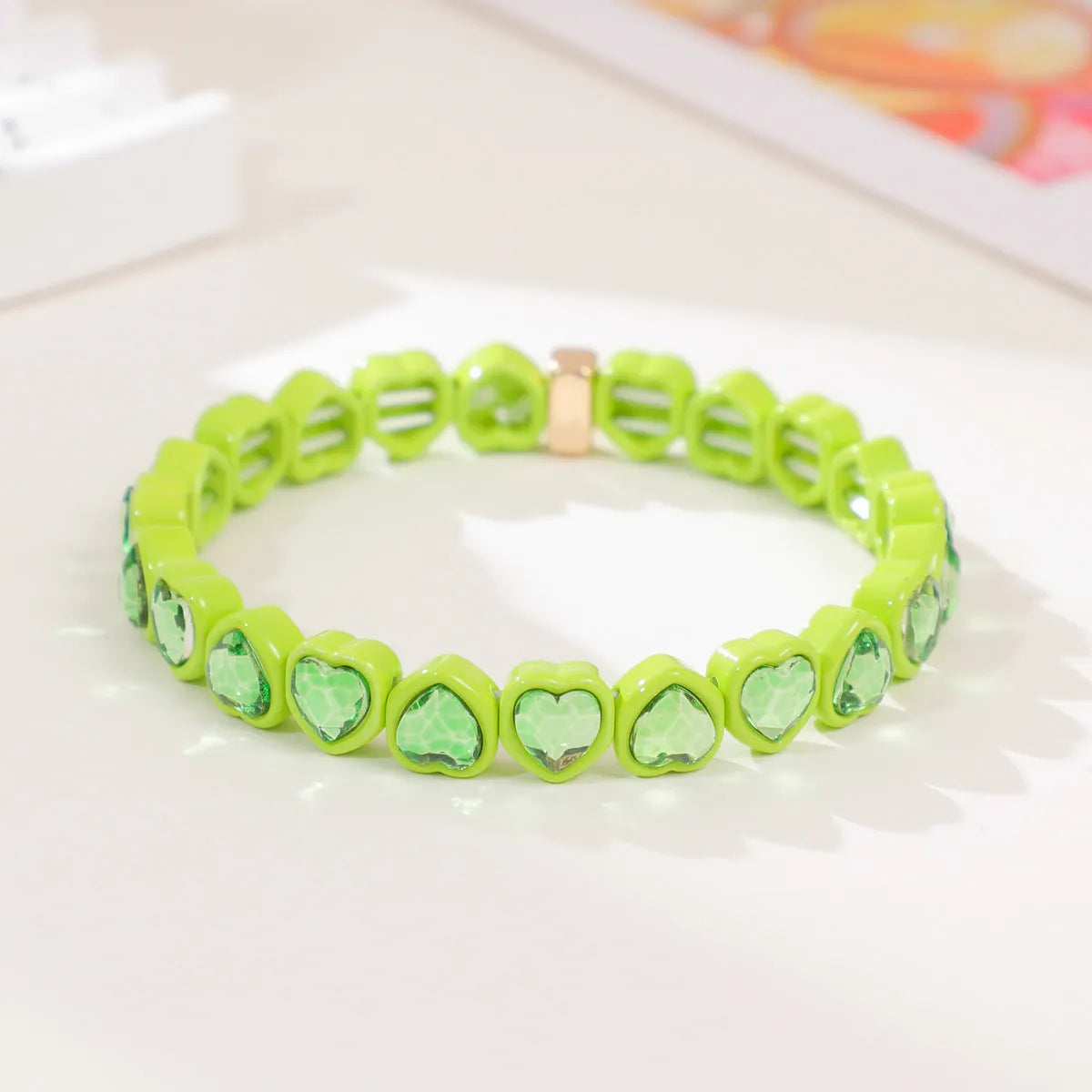Colourful enamel heart shape on a silver-toned alloy stretch bracelet.