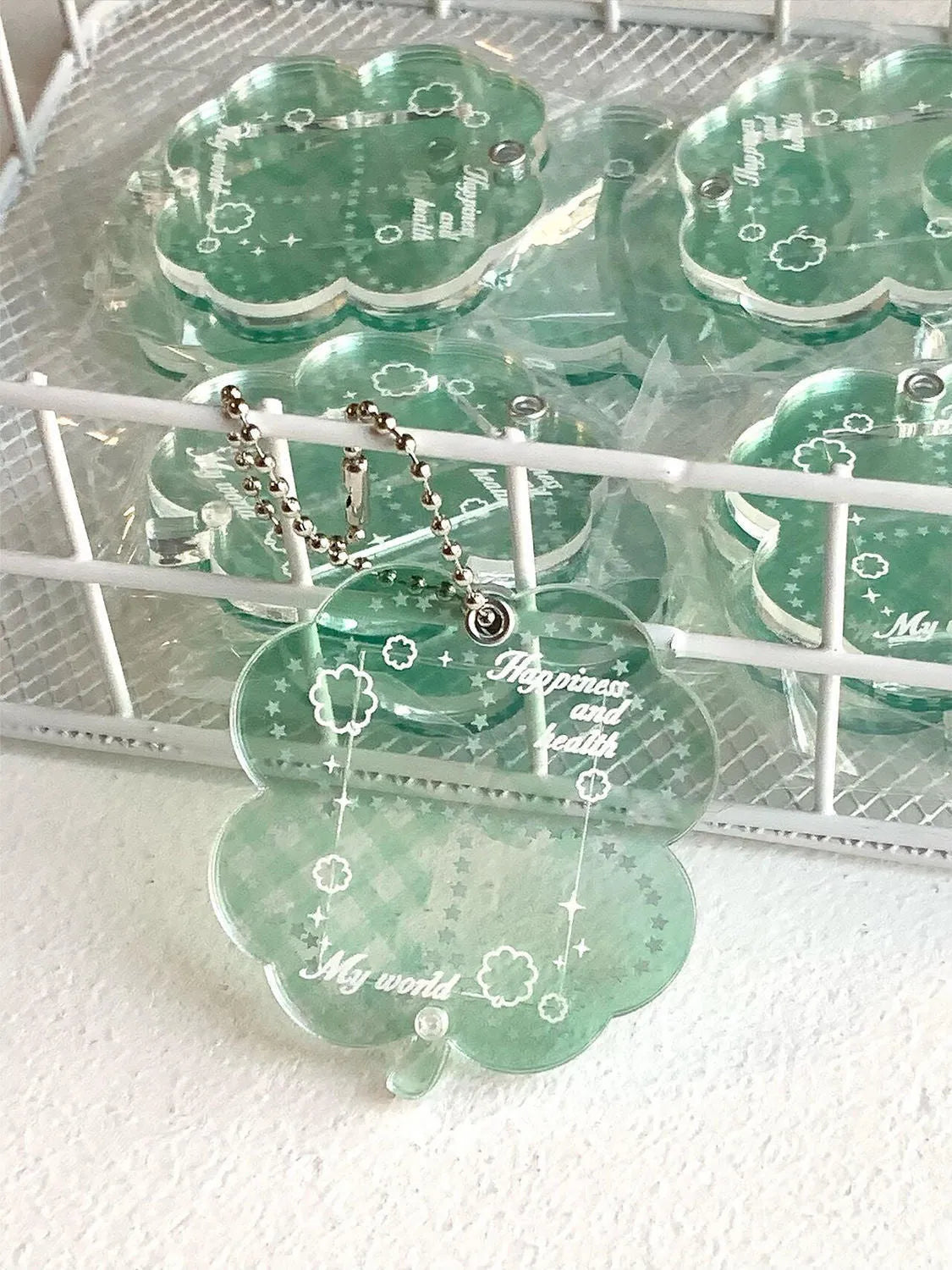 Four-leaf clover shaped acrylic phone pendant keychain in blue, green, and mint colour options