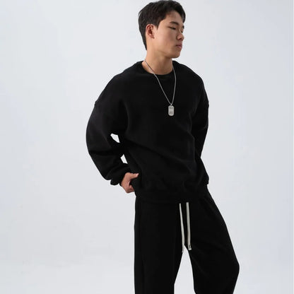 Man wearing a loose-fit army green polar fleece tracksuit with a crew neck jacket and matching padded trousers.