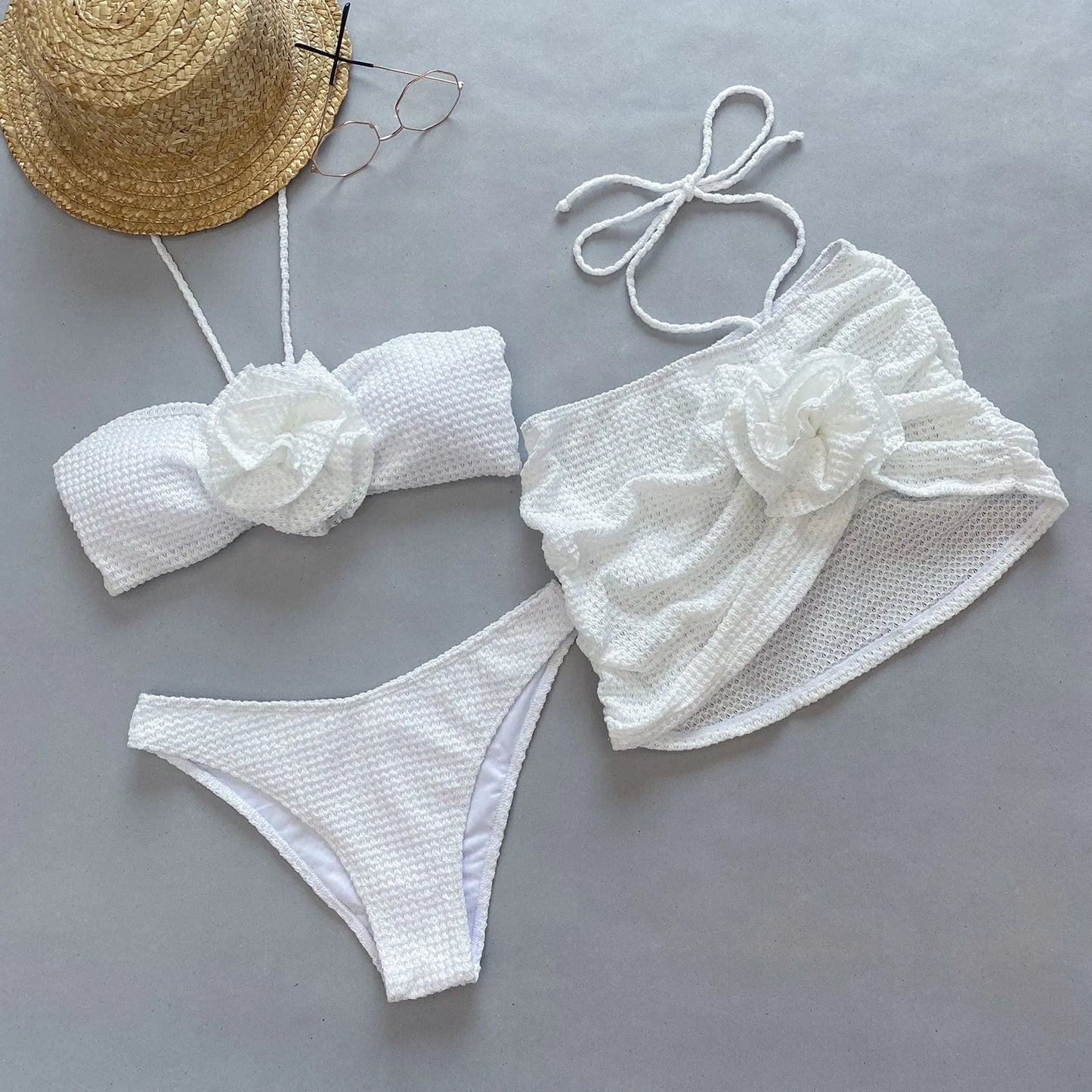 White women's three-piece bikini with 3D floral appliqué on the briefs and a matching lace skirt.