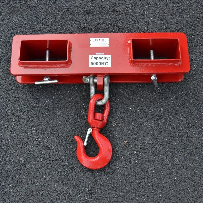 Heavy-duty iron forklift hook with rotatable drum and safety locking latch, shown mounted on forklift forks.