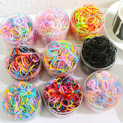 Assorted colourful thin TPU baby hair ties for toddlers and kids in a reusable plastic storage container.