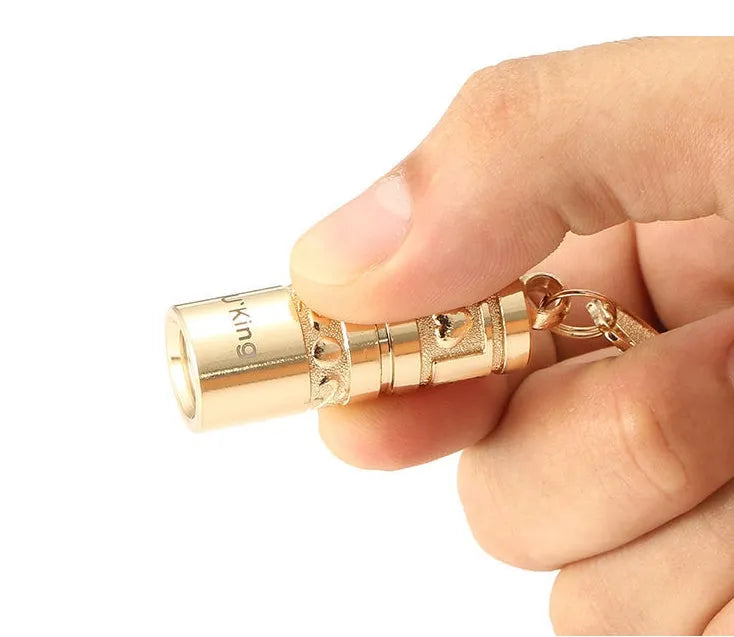 Gold zinc alloy keychain torch with LED light, shown attached to a keyring.