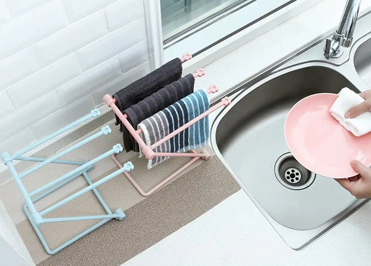 Foldable plastic dishcloth shelf organiser in light blue mounted on a wall.