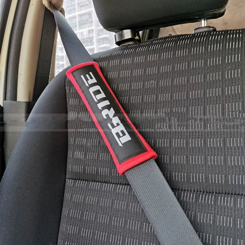 Car seat belt shoulder pad protectors in black, blue, and red colours with embroidered woven detailing