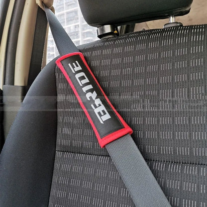 Car seat belt shoulder pad protectors in black, blue, and red colours with embroidered woven detailing