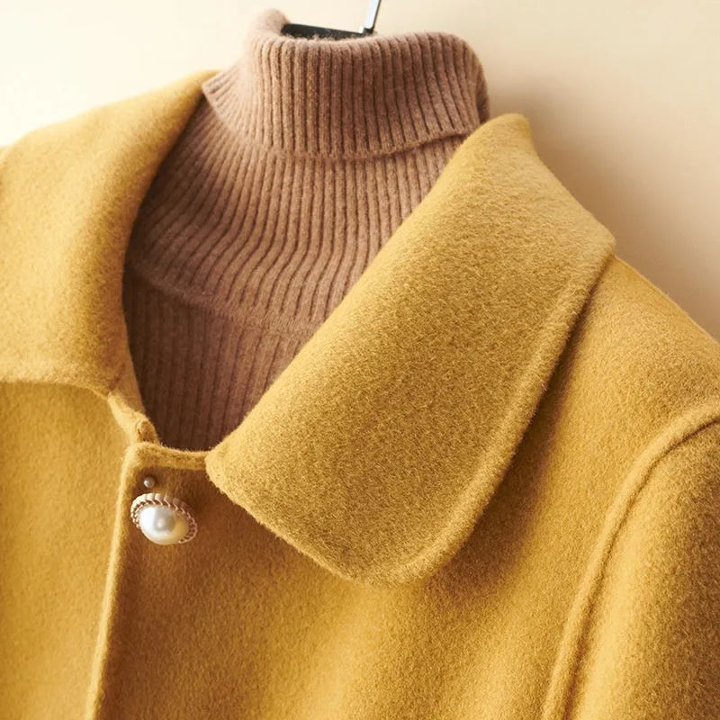 Women's double-faced wool mid-length coat with a doll collar and pearl buckle detail in a solid colour.