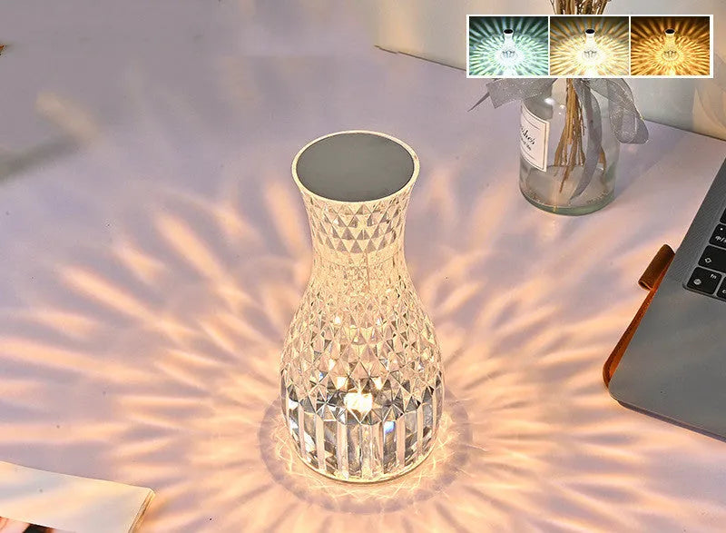 Vase-shaped crystal table lamp with remote control on a bedside table, showing diamond-like glow and USB charging port.