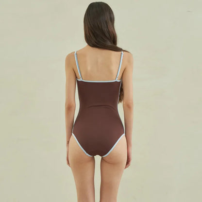 Brown women's one-piece swimsuit with triangle front and adjustable tie-back straps on a neutral background.