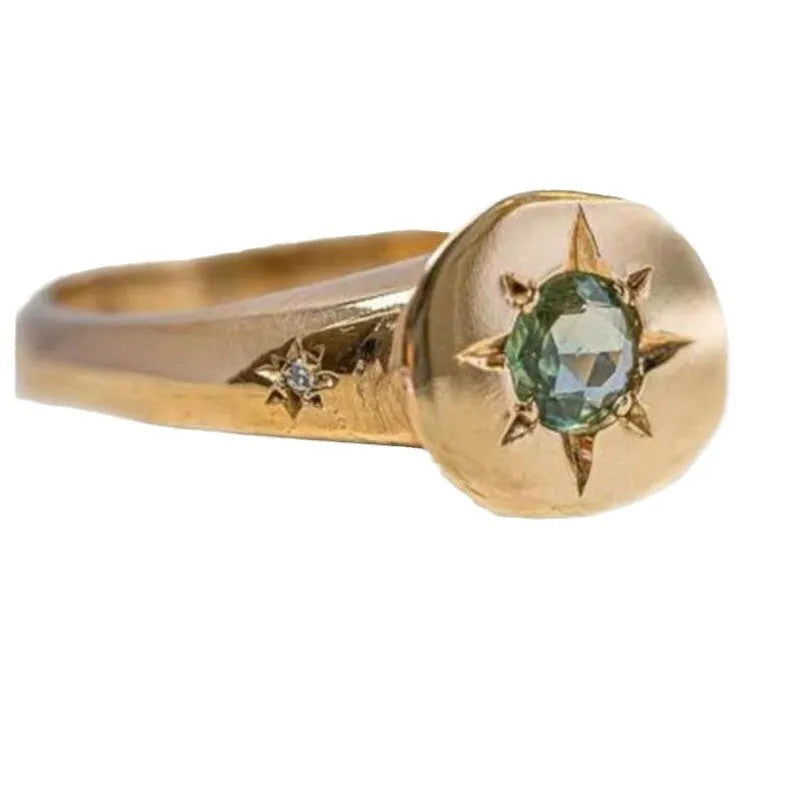 Golden ring with oval asterism zircon, star shape, and adjustable opening on a plain background