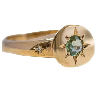 Golden ring with oval asterism zircon, star shape, and adjustable opening on a plain background