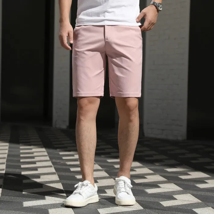 Man wearing loose-fit beige fifth pants with an elastic waistband, showcasing the mid-length casual style.