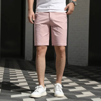 Man wearing loose-fit beige fifth pants with an elastic waistband, showcasing the mid-length casual style.