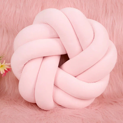 Knotted lumbar pillow with memory foam fill showing adjustable height feature and polyester cover