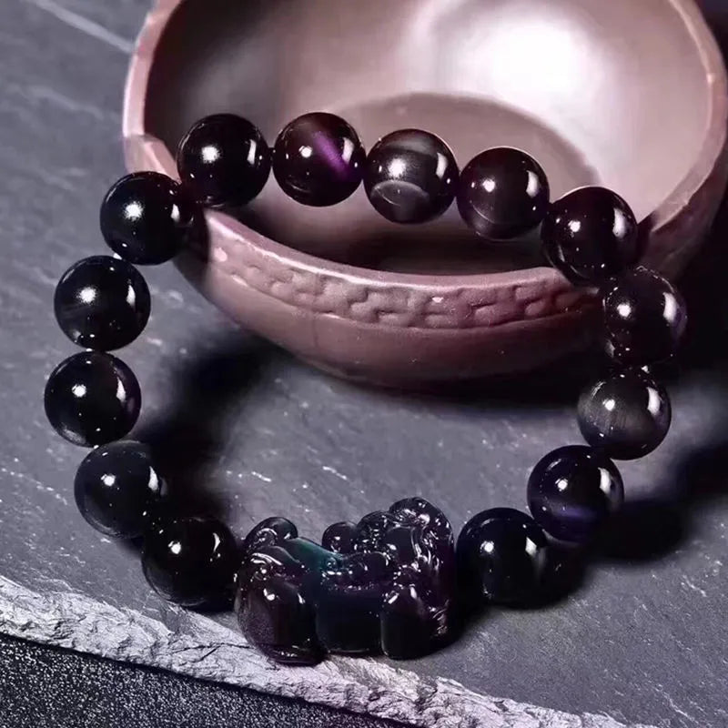 Natural Ice Colour Eye Obsidian crystal bracelet on wrist, showing translucent beads.