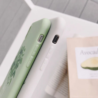 White silicone iPhone case with a painted green leaf plant design on the back.