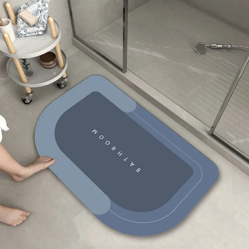 Oval diatomite bathroom floor mat in blue with natural rubber non-slip backing on tiled floor.