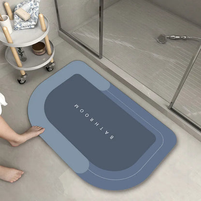 Oval diatomite bathroom floor mat in blue with natural rubber non-slip backing on tiled floor.