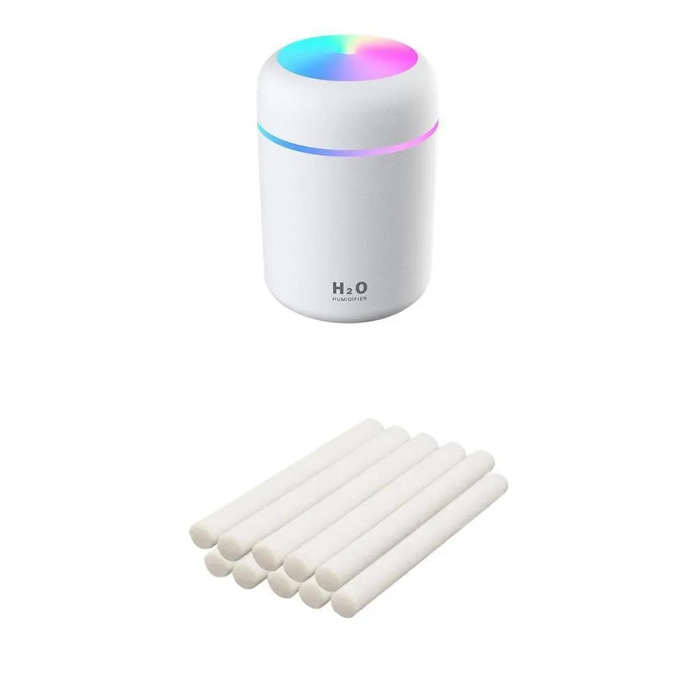 Pink USB desktop humidifier with LED lights and water tank on wooden desk