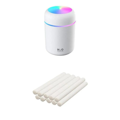 Pink USB desktop humidifier with LED lights and water tank on wooden desk