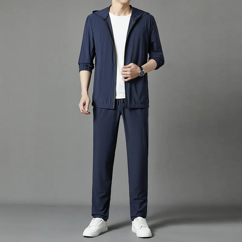 Grey hooded sun-protective top and loose pants suit for men on a hanger.