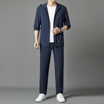 Grey hooded sun-protective top and loose pants suit for men on a hanger.