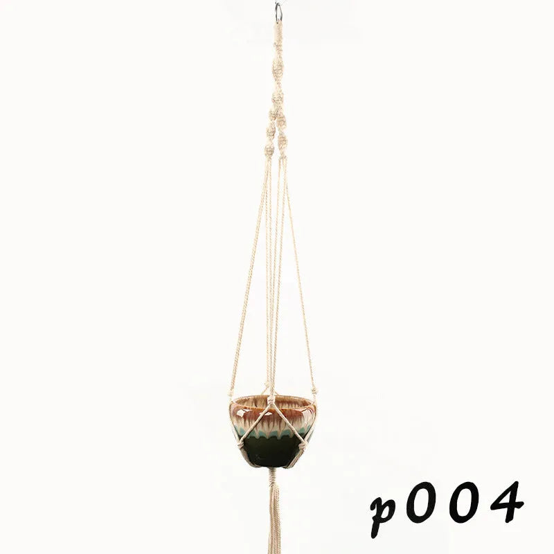 Handwoven natural cotton rope plant hanger cradling a green potted succulent on a wooden table.