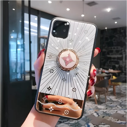 Luxury diamond and gold ring stand attached to the back of an iPhone in rose gold colour.