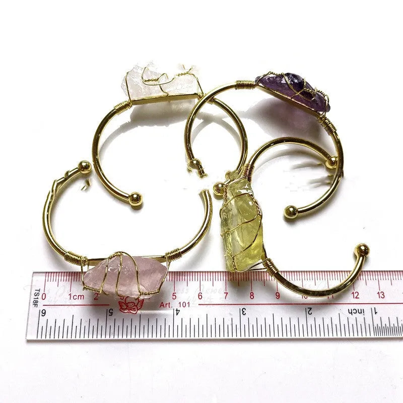 Natural gold winding crystal rough stone bracelet with unshaped geometric design on a wrist.