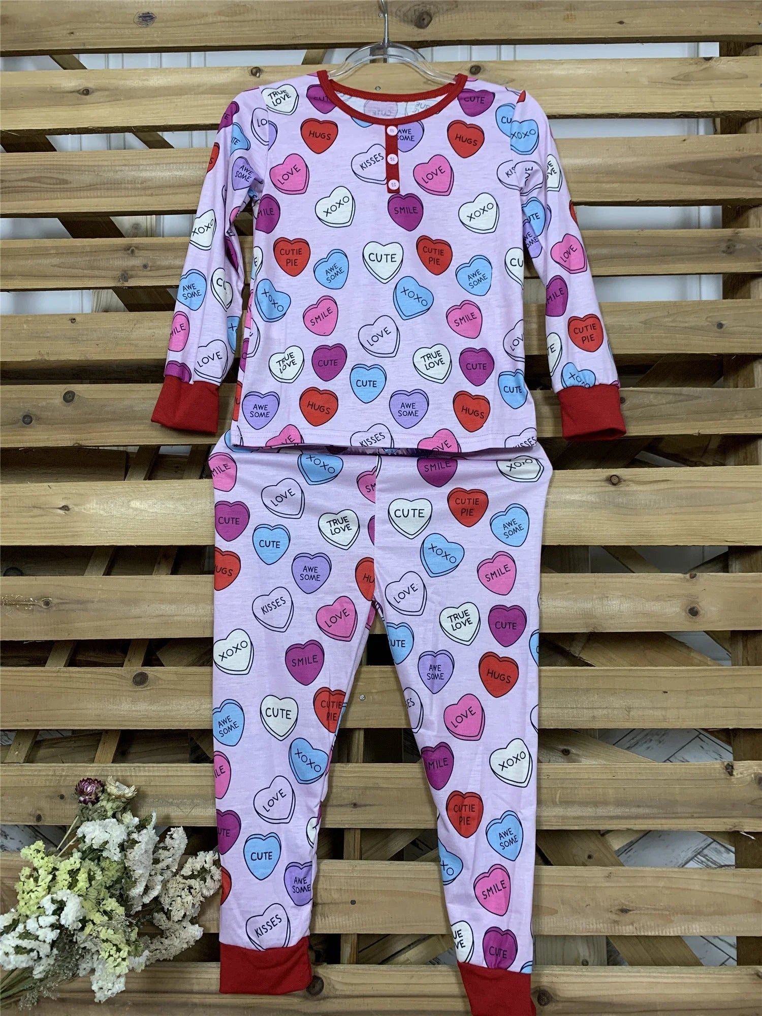 Adorable heart-printed family pajamas with long-sleeve tops and full-length bottoms in a range of sizes for children and adults.