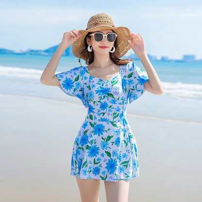 Blue floral print women's dress-style one-piece swimsuit on a hanger