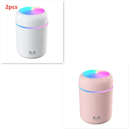 Pink USB desktop humidifier with LED lights and water tank on wooden desk