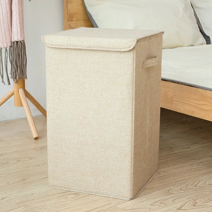 Foldable cube-shaped laundry basket in cotton linen fabric, shown in brown colour.