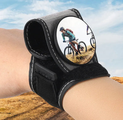 Black nylon bicycle rear-view mirror mounted on a cyclist's wrist.