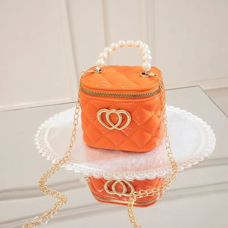 White PVC women's bucket bag with a heart-shaped pattern and shoulder strap.
