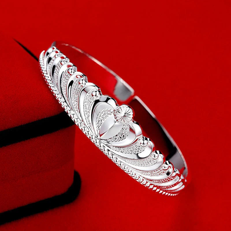 A close-up view of the elegant Crown Bracelet, showcasing its intricate crown-shaped design and shiny, rhodium-plated finish.