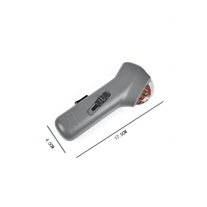 Grey-coloured pet treat catapult launcher for dogs and cats on a plain background.