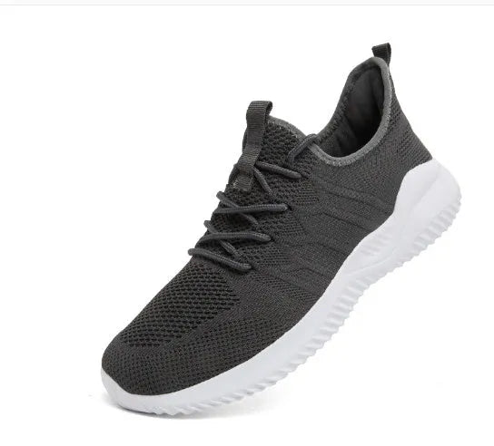 Men's black and white breathable mesh sneakers with round toe and lace-up closure on a grey background.