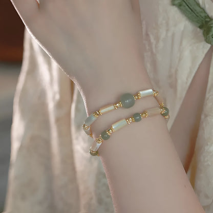 Hetian Jade white lip shell bracelet with geometric round beads on wrist