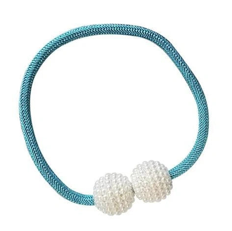 Magnetic curtain tiebacks with white pearl beads and fabric loops holding gathered curtain