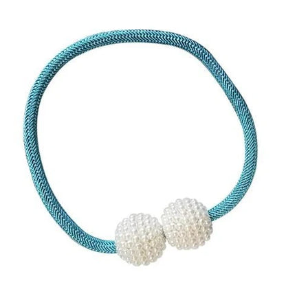 Magnetic curtain tiebacks with white pearl beads and fabric loops holding gathered curtain