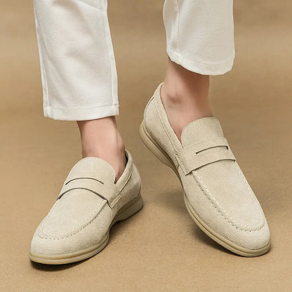 Men's beige leather slip-on shoes with a round toe and mid heel on a rubber sole.
