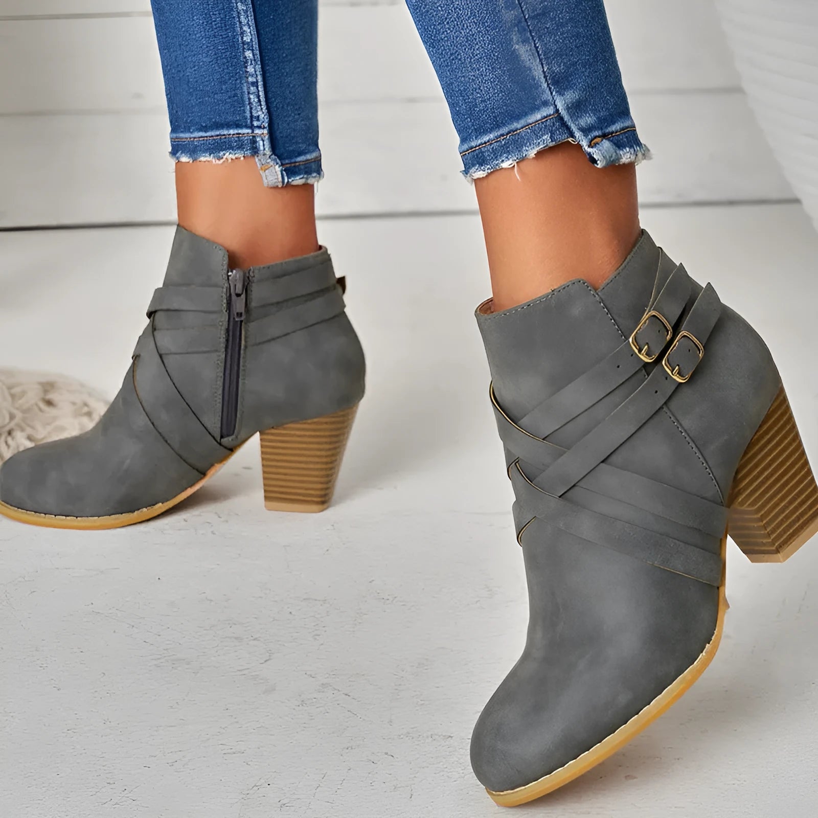 Women's short ankle boots with a belt buckle and side zip in black, brown, or grey with a 7cm heel.